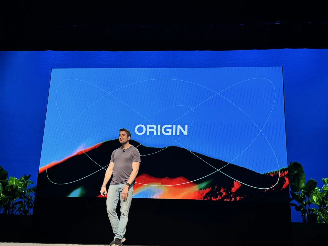 Cursorのステージに製品名「ORIGIN」が映し出され、登壇者が発表している様子